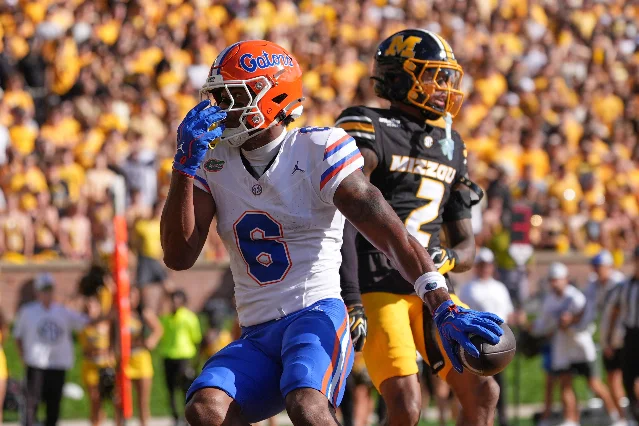 Florida receiver Dallas Wilson celebrates a touchdown catch with Missouri cornerback Sione Laulea defending