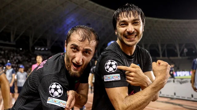 Two Sabah players point to the Champions League starball badge on their sleeves