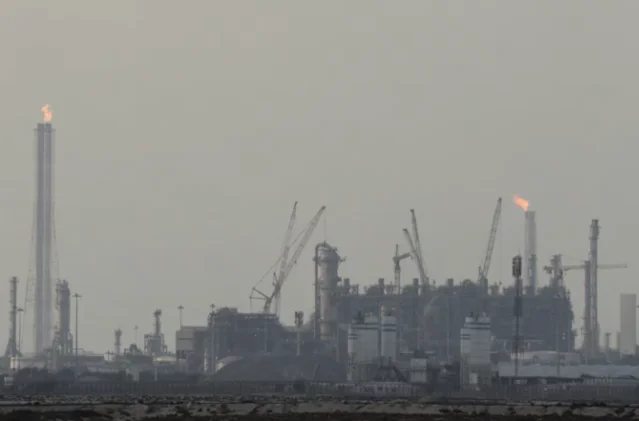 QatarEnergy LNG production facilities at Ras Laffan Industrial City — gas flares visible against the haze