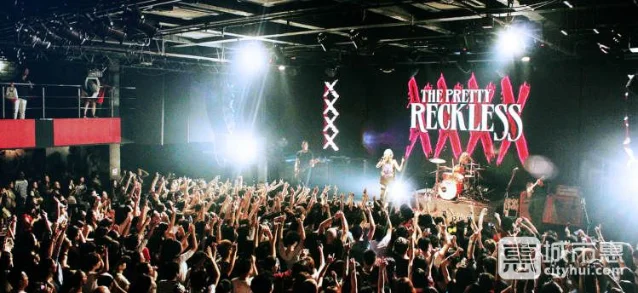 MAO LIVEHOUSE 演出现场,乐队在台上演出,台下观众高举双手互动