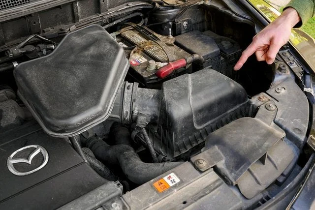 Finger pointing to the engine air-filter housing