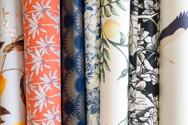 Rolls of peel-and-stick wallpaper samples being tested for adhesion and clean removal