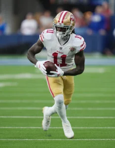 Brandon Aiyuk in a 49ers uniform, mid-route during a 2024 game