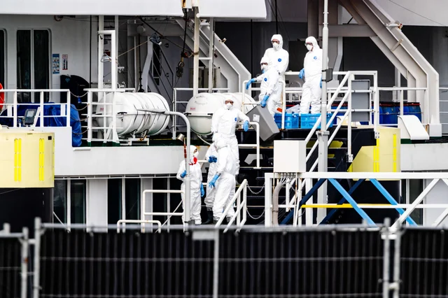 PPE-suited personnel on the deck of MV Hondius at Rotterdam port, 19 May 2026