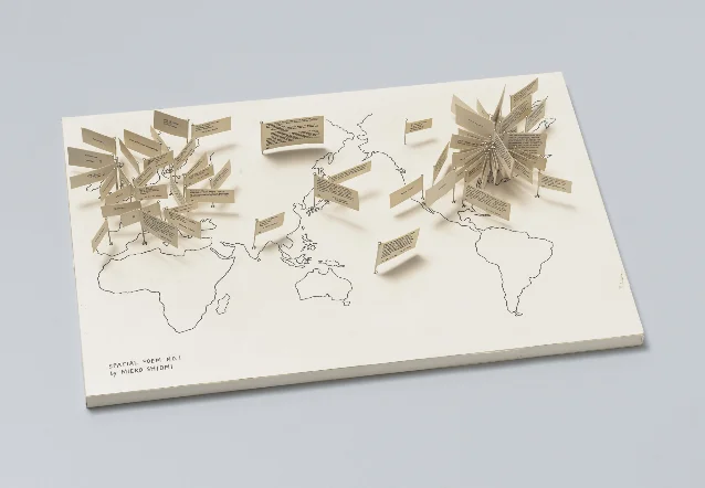 米色底板上的世界地图插着许多写有词语的纸旗,呈现盐见允枝子《Spatial Poem No. 1》的对象版