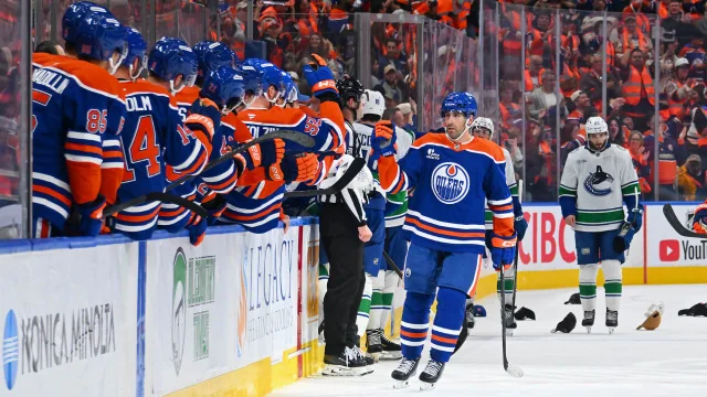 Edmonton Oilers players celebrating at their bench during the opening week