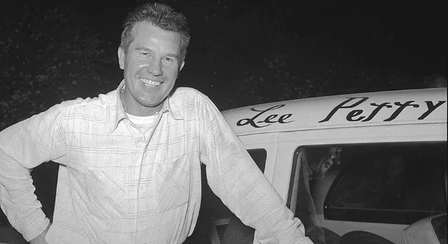 Lee Petty beside a stock car bearing his name.