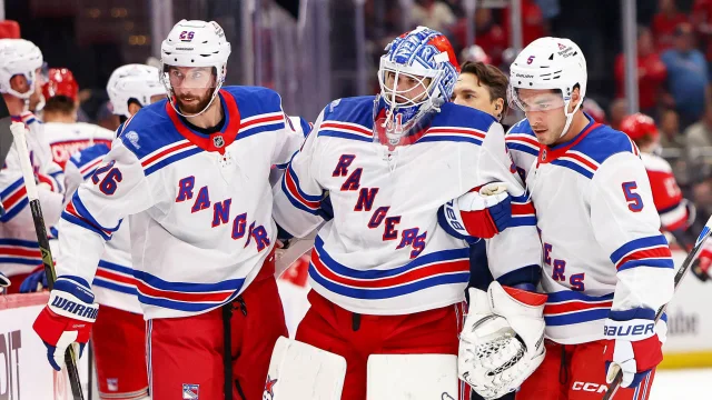 Rangers players supporting goalie Igor Shesterkin as he leaves the ice