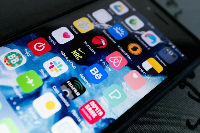 Hand holding smartphone with app icons on screen