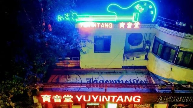 育音堂外墙夜景,霓虹吉他灯和育音堂字样清晰可见