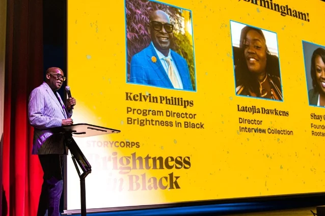 Kelvin Phillips speaks beside a Brightness in Black screen