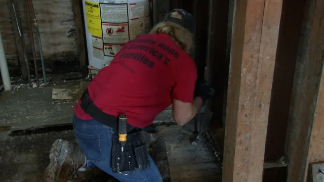 A Christ in Action volunteer works in a flood-damaged basement in West Virginia