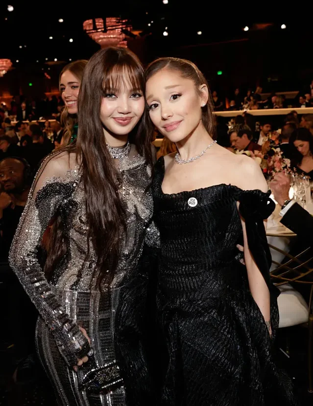 Grande at the 2026 Golden Globes, wearing an "ICE OUT" pin, alongside singer Lisa (Francis Specker/CBS via Getty Images)