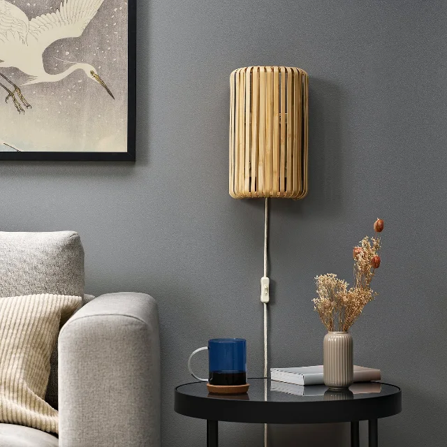 VARPTROSS bamboo wall lamp mounted beside a sofa