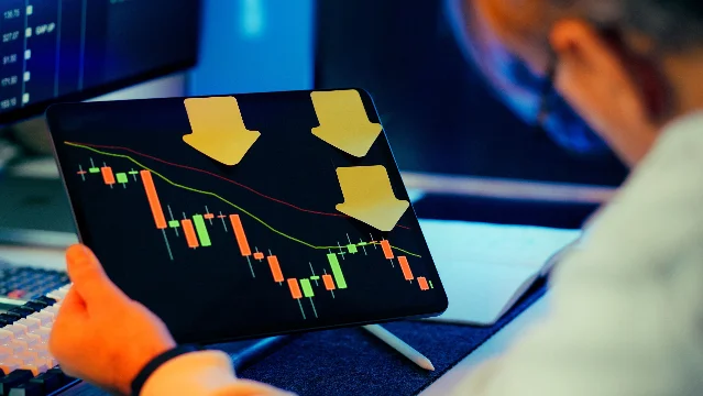 A businessman examining a downward stock chart on a digital screen, representing Cendant's 46% single-day share price collapse on April 16, 1998