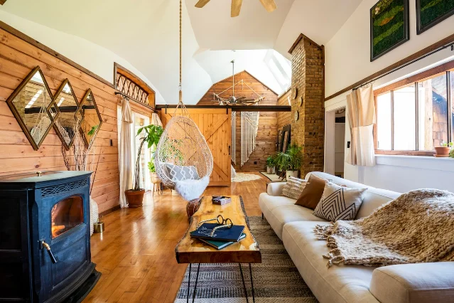 Wood-lined living room inside the Gingerbread House Tower, with a hanging chair and skylit ceiling