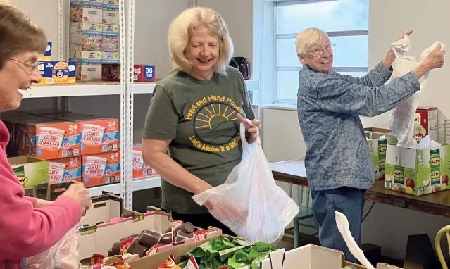 Volunteers form a small assembly line for the Barbour County Backpack Program.