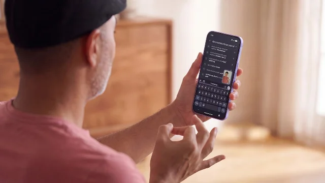 A person holds a smartphone showing Google DeepMind's sign-language-to-text interface