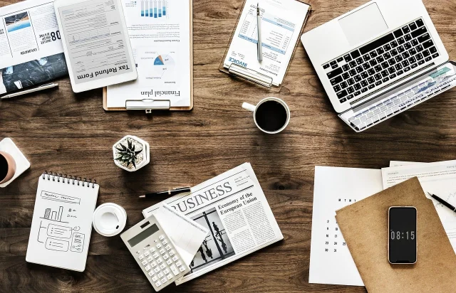 Paperwork and a laptop spread across a desk