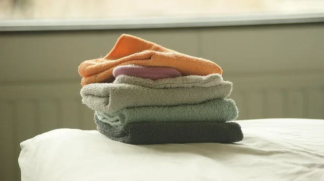 A stack of folded towels on a bed