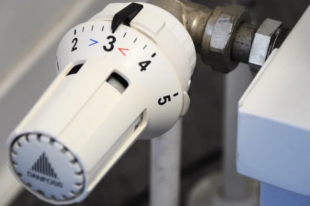 A white thermostatic radiator valve with a numbered dial, photographed close up