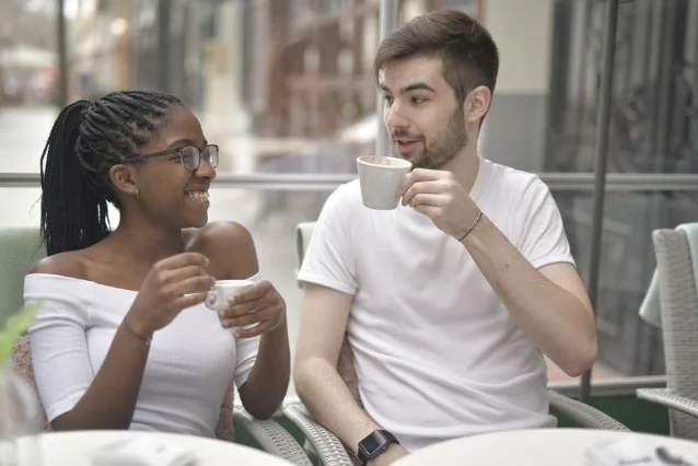 Happy diverse couple sharing a moment over coffee