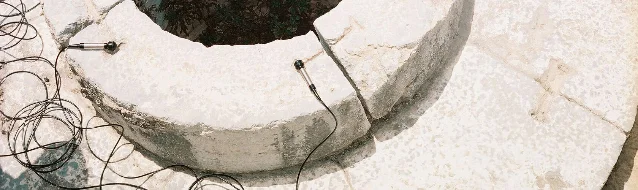 白色石砌水槽边缘贴着接触式麦克风,黑色线缆沿石面盘绕