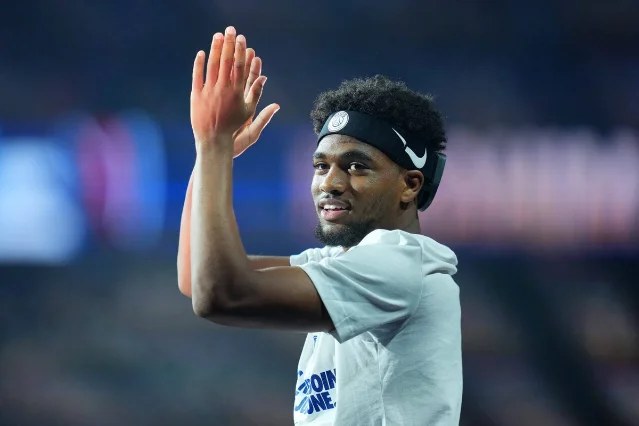 Ibrahim Mbaye applauds supporters in a Paris Saint-Germain headband