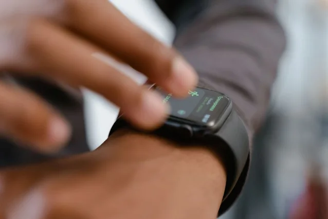 Person using a smartwatch to check fitness data, tapping the screen with one finger