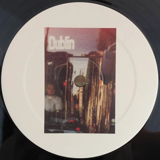 The 12-inch vinyl record for Heavy Dublin, showing a white center label with a moody printed photograph of a Dublin street scene and the word "Dublin" at the top