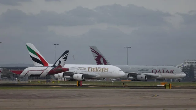 Emirates and Qatar Airways aircraft on an airport tarmac