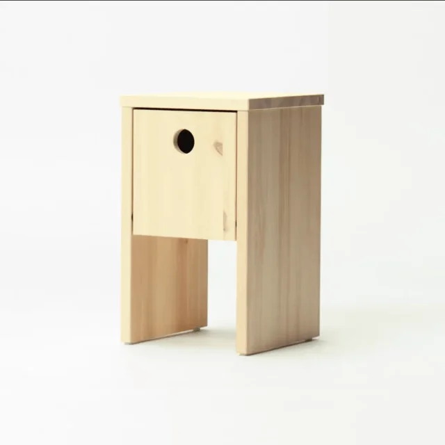 IKEA PS 2026 nightstand in solid pine with the birdhouse-style circular opening as door handle, fold-down front storage
