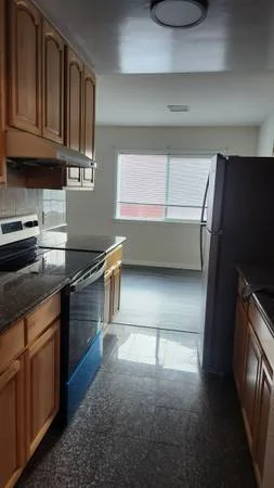 Kitchen at 80 Vernon St, Adams Point, Oakland — dark granite counters, electric range, full-size fridge