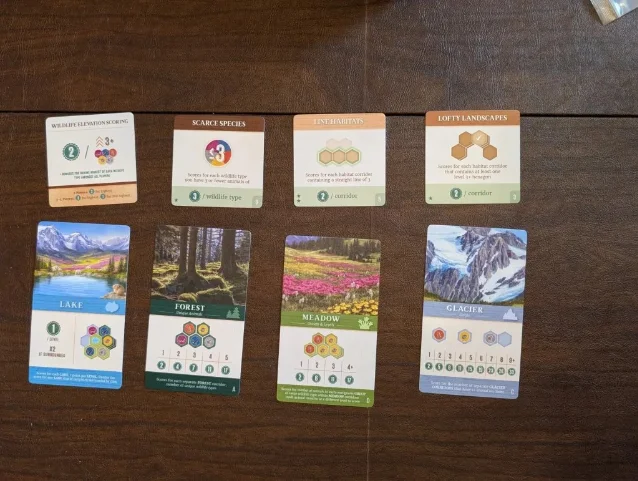 Cascadia: Alpine Lakes habitat cards and scoring cards laid out on a wooden table