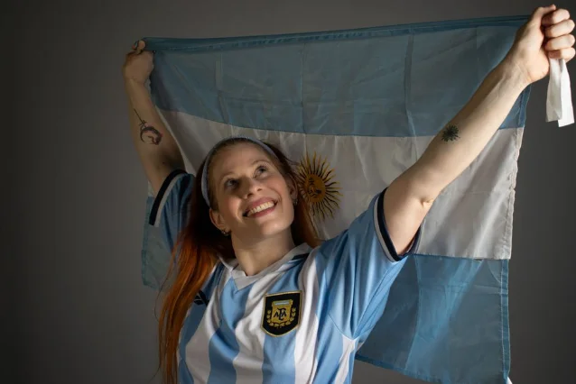 Argentina fans celebrating with flags in blue and white jerseys
