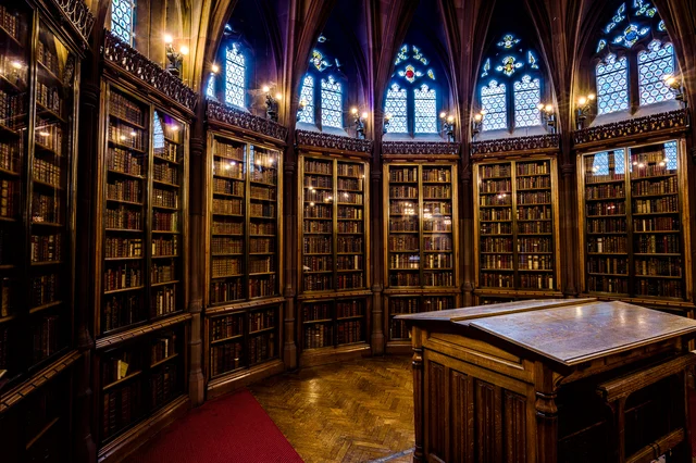 Interior of a historic Gothic library with towering bookshelves and ornate architecture