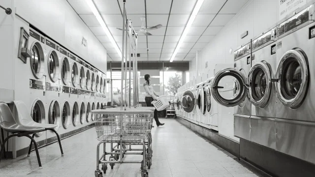 A laundromat aisle with rows of washing machines