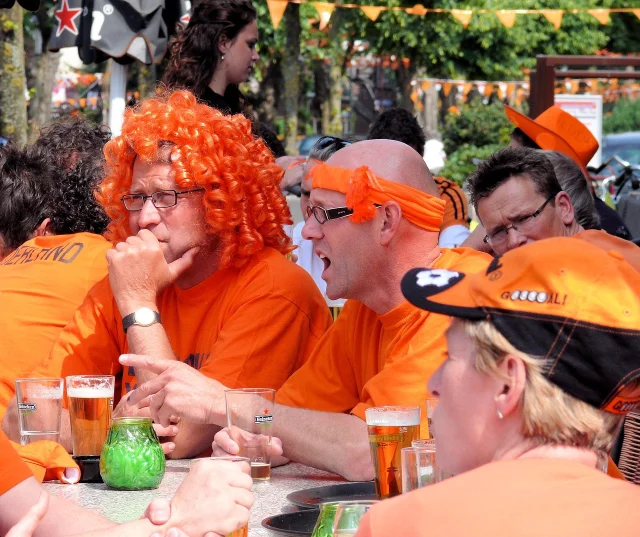 Orange-clad football fans filling a stadium — the Dutch support is loud, loyal, and perpetually optimistic