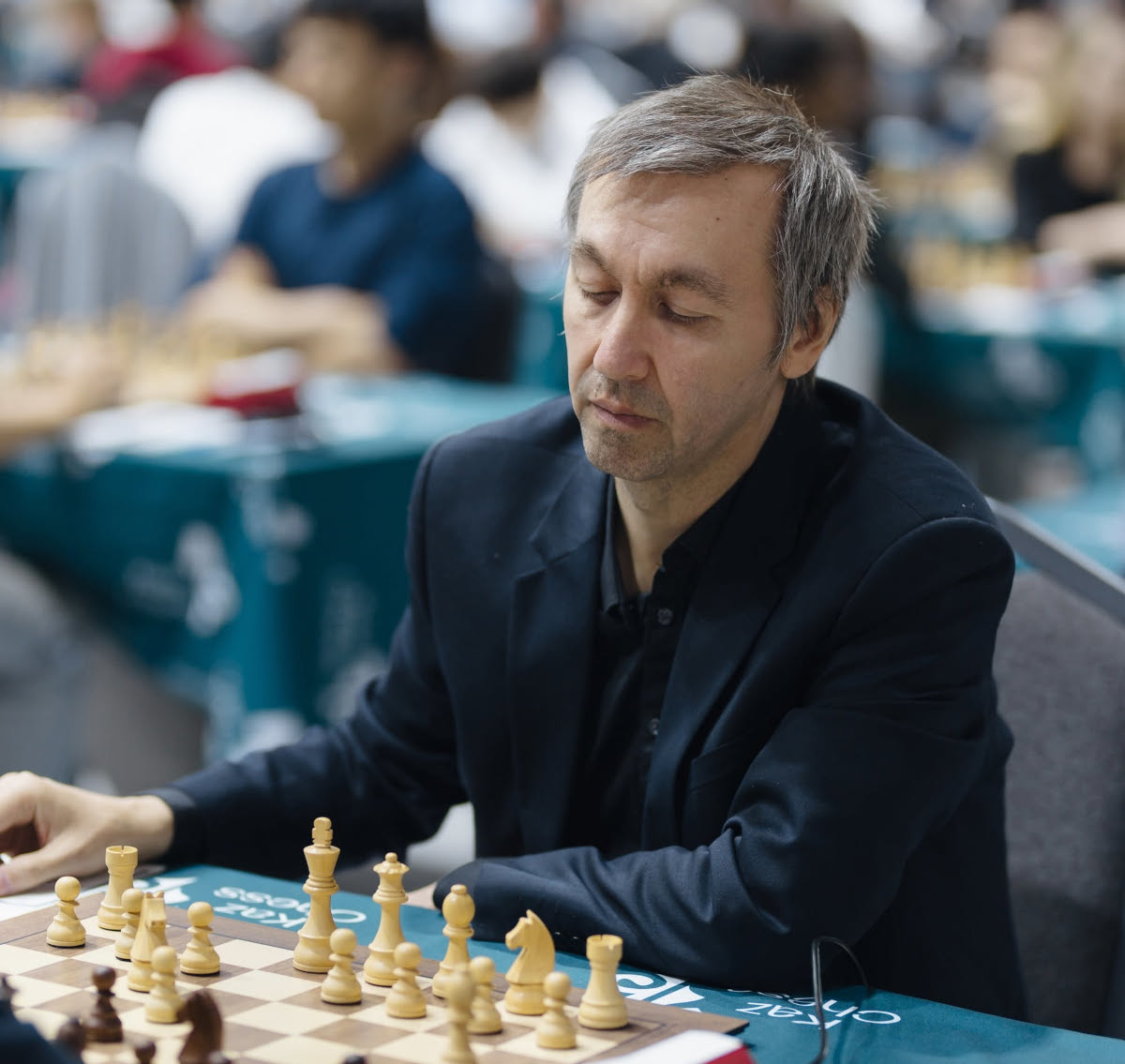 Gata Kamsky at his board in the Masters section, other games in the background