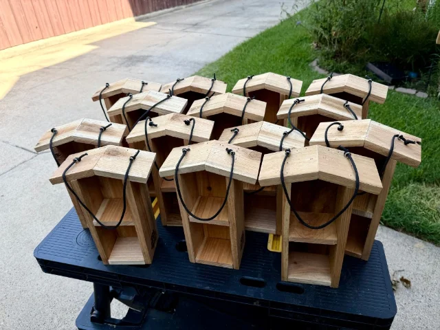 Fourteen small wooden bug hotels made for a children's nature class