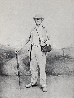 Hilaire Belloc standing with a walking stick after reaching Rome