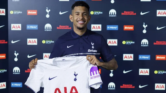 Sávio holding a white Tottenham shirt at his unveiling