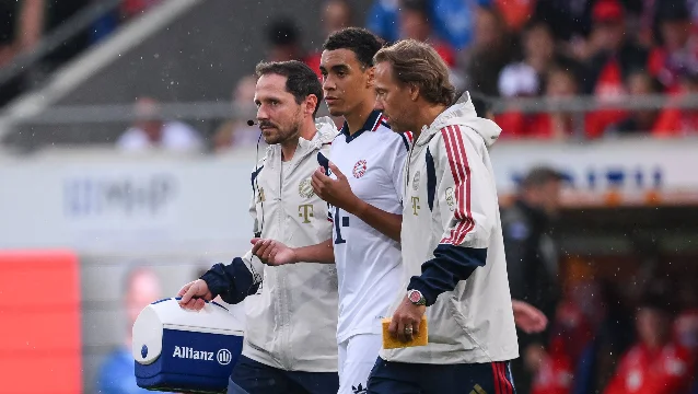 Jamal Musiala walks off with Bayern staff after the Heidenheim friendly.