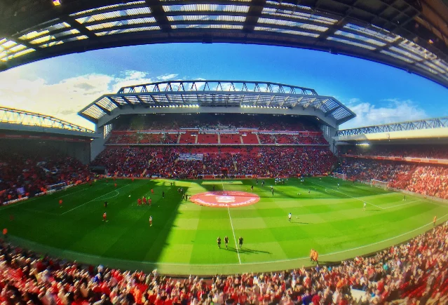 Panoramic interior view of Anfield with the pitch, red stands and the new Main Stand