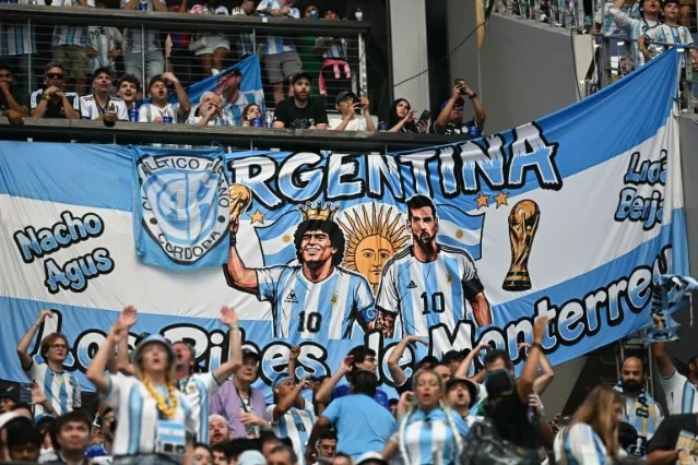 Argentina supporters hold a Maradona and Messi banner