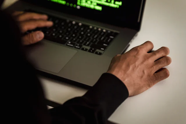 Developer writing code on a laptop, overhead view — illustrating the kind of focused problem-solving Amazon evaluates across behavioral and technical rounds