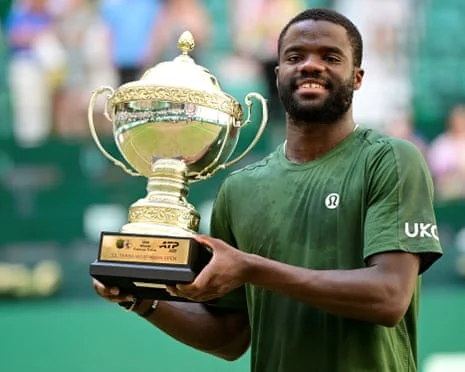 Frances Tiafoe raises the Halle Open trophy on the grass court, June 21