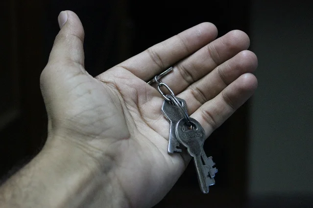 An open hand holding a small bunch of keys on a ring