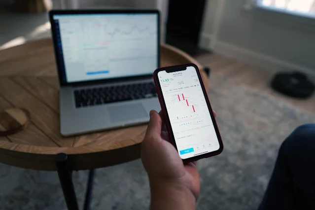 A financial analyst reviewing market data and stock charts on a trading workstation