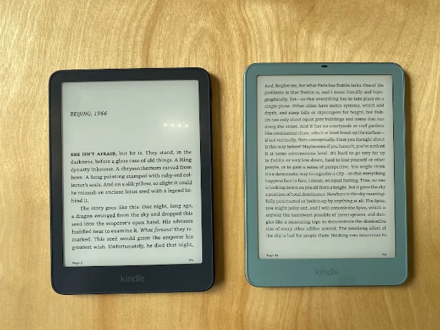 Two of Amazon's redesigned Kindle e-readers side by side on a wooden surface